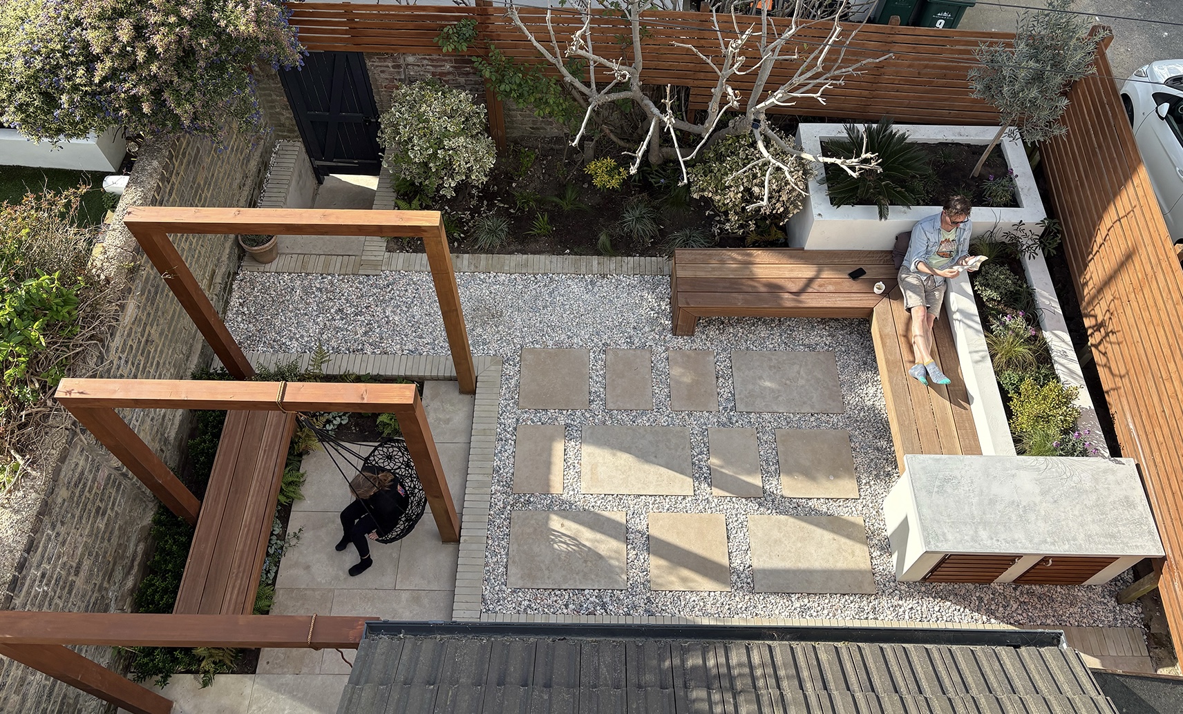 A limestone patio and gravel with a softwood pergola in a compact Port Hall garden in Brighton, by Brunswick Landscapes